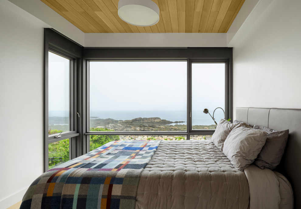Immagine di una camera degli ospiti stile marino con pareti bianche, parquet chiaro e soffitto in legno