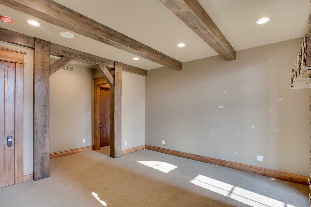 Inspiration for a mid-sized rustic master carpeted home design remodel with beige walls, a two-sided fireplace and a stone fireplace