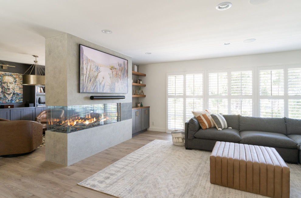 This is an example of a medium sized traditional living room in Orange County with blue walls, vinyl flooring, a corner fireplace, a concrete fireplace surround, brown floors and wallpapered walls.