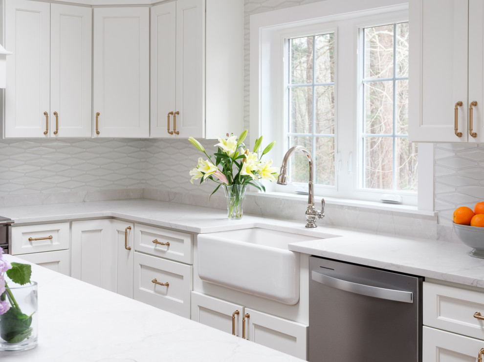 Inspiration for a large transitional l-shaped medium tone wood floor and brown floor kitchen remodel in Boston with white cabinets, white backsplash, an island and white countertops