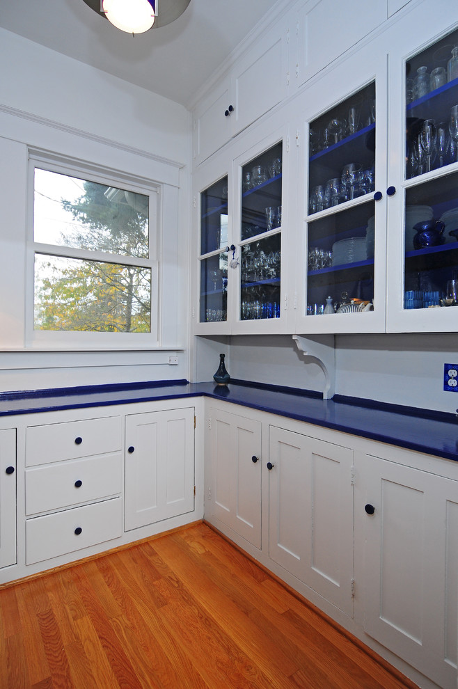 Mid-sized transitional u-shaped medium tone wood floor kitchen pantry photo in Seattle with a double-bowl sink, shaker cabinets, white cabinets, solid surface countertops, blue backsplash, ceramic backsplash, white appliances, white walls and no island