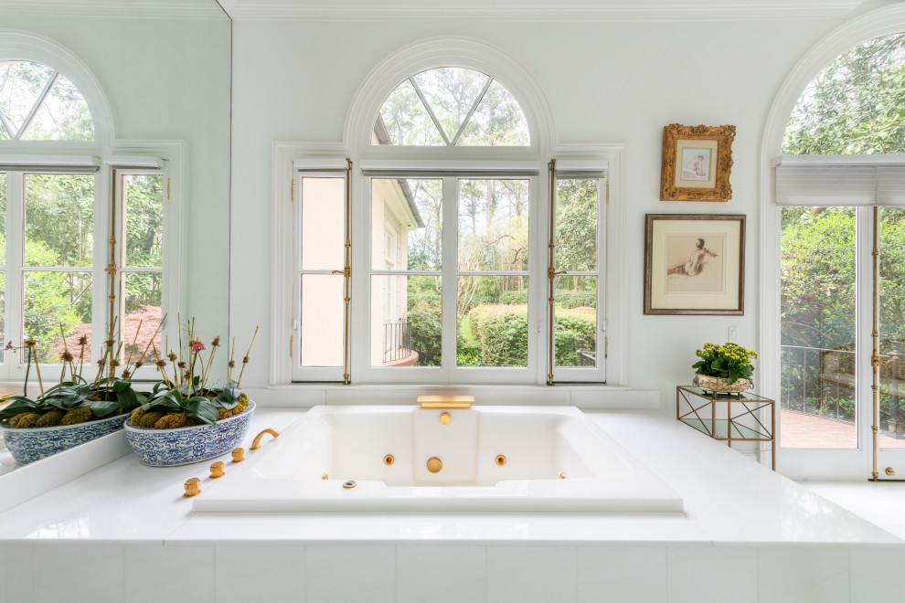 Immagine di un'ampia stanza da bagno padronale tradizionale con ante con bugna sagomata, ante bianche, vasca da incasso, piastrelle bianche, piastrelle in ceramica, pareti rosa, pavimento bianco, top bianco, due lavabi e mobile bagno incassato