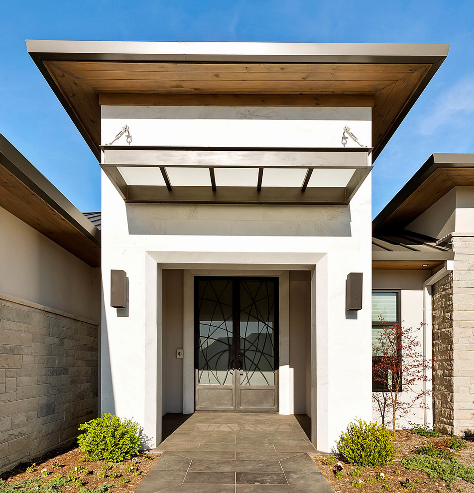 This is an example of a mid-sized contemporary one-storey adobe white exterior in Dallas with a flat roof.