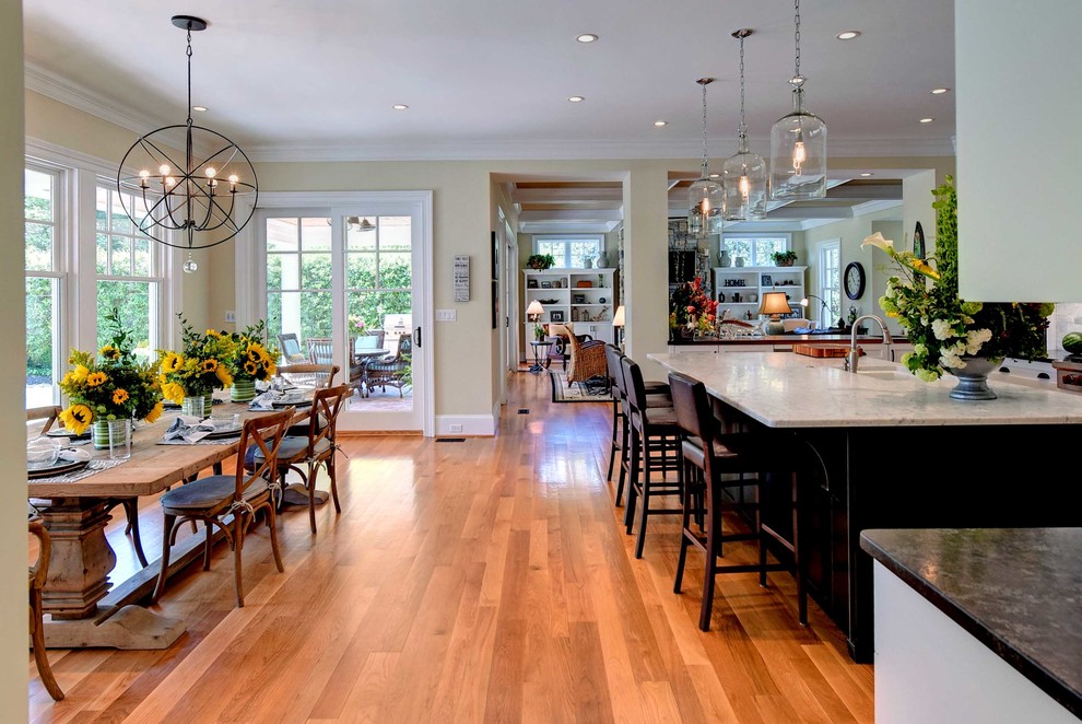 Inspiration for a transitional medium tone wood floor eat-in kitchen remodel with an undermount sink, shaker cabinets, white cabinets, marble countertops, gray backsplash, subway tile backsplash, stainless steel appliances and an island