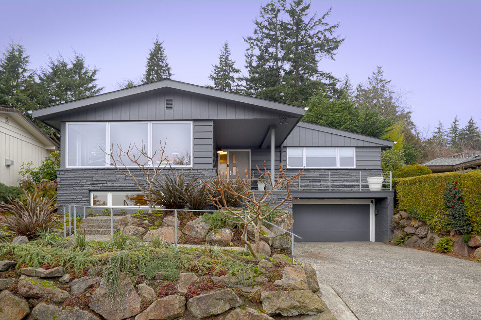 Midcentury two-storey grey house exterior in Seattle with a gable roof.