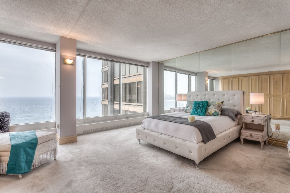 This is an example of a contemporary master bedroom in Toronto with white walls and carpet.