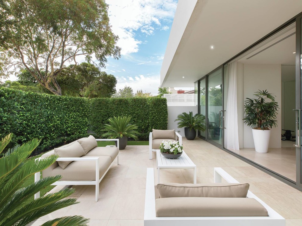 Mid-sized contemporary courtyard patio in Melbourne with natural stone pavers.