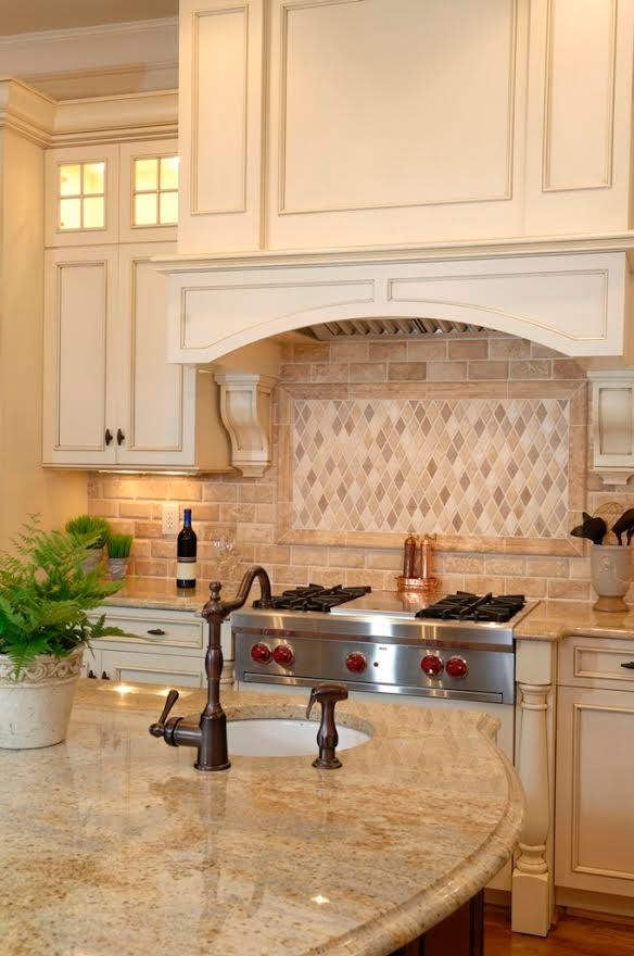 Design ideas for a mid-sized traditional separate kitchen in Dallas with an undermount sink, recessed-panel cabinets, beige cabinets, limestone benchtops, beige splashback, brick splashback, stainless steel appliances, medium hardwood floors and with island.