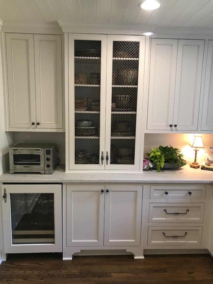 Example of a large transitional u-shaped dark wood floor and brown floor eat-in kitchen design with an undermount sink, recessed-panel cabinets, white cabinets, marble countertops, white backsplash, subway tile backsplash, stainless steel appliances, an island and white countertops