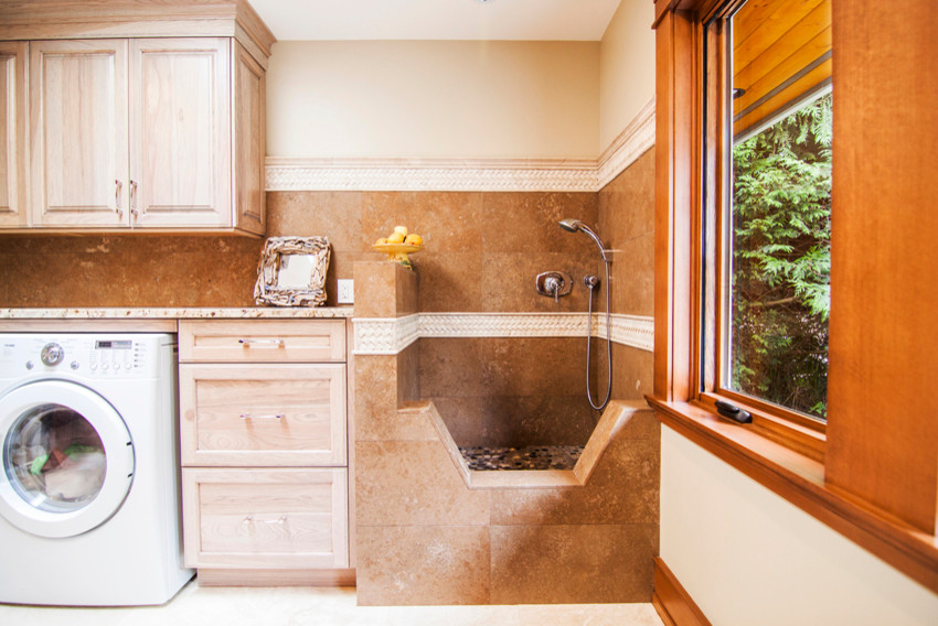 Mid-sized transitional single-wall utility room in Vancouver with raised-panel cabinets, light wood cabinets, granite benchtops, beige walls, travertine floors and a side-by-side washer and dryer.