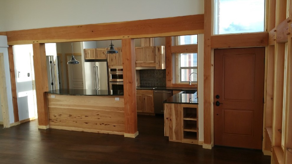 Mid-sized mountain style l-shaped dark wood floor kitchen photo in Seattle with shaker cabinets, light wood cabinets, black backsplash, stainless steel appliances and an island