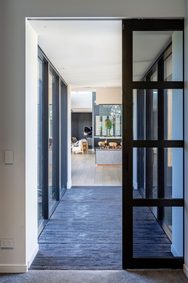 Design ideas for a large contemporary hallway in Auckland with dark hardwood floors and brown floor.