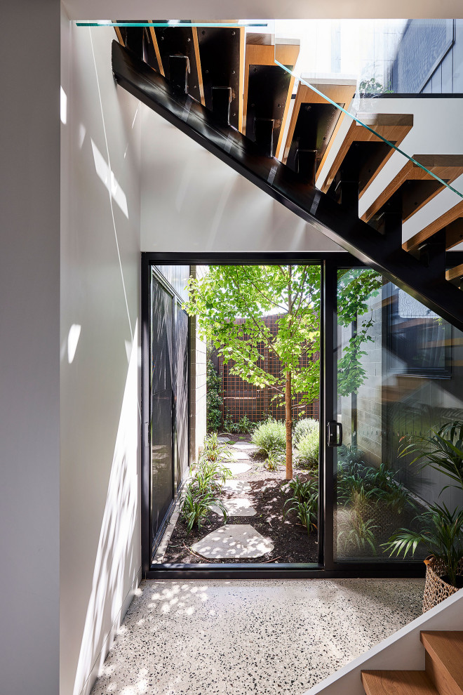 Example of a large trendy wooden straight open and glass railing staircase design in Geelong