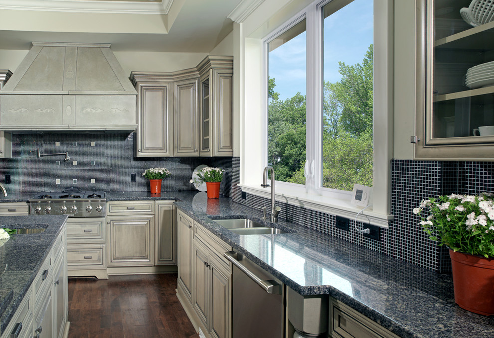 Example of a large transitional l-shaped dark wood floor and brown floor open concept kitchen design in Columbus with a double-bowl sink, raised-panel cabinets, beige cabinets, granite countertops, blue backsplash, mosaic tile backsplash, stainless steel appliances and an island