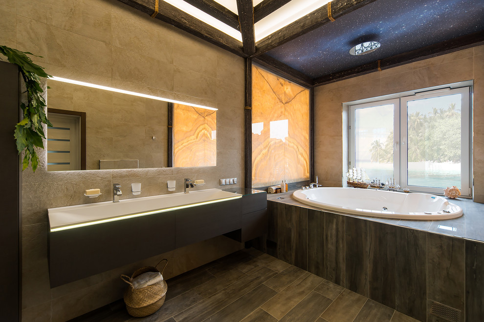 Photo of a large eclectic master bathroom in Moscow with flat-panel cabinets, grey cabinets, a hot tub, a wall-mount toilet, beige tile, porcelain tile, beige walls, porcelain floors, an integrated sink, recycled glass benchtops, grey floor and grey benchtops.