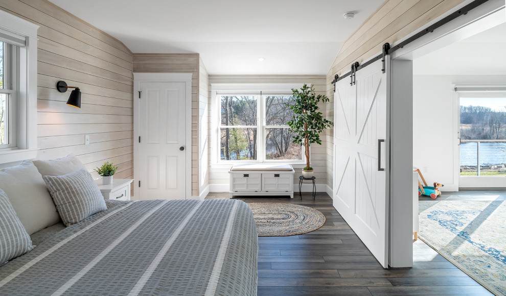 Maritimes Schlafzimmer mit beiger Wandfarbe, dunklem Holzboden, braunem Boden und Holzwänden in Portland Maine