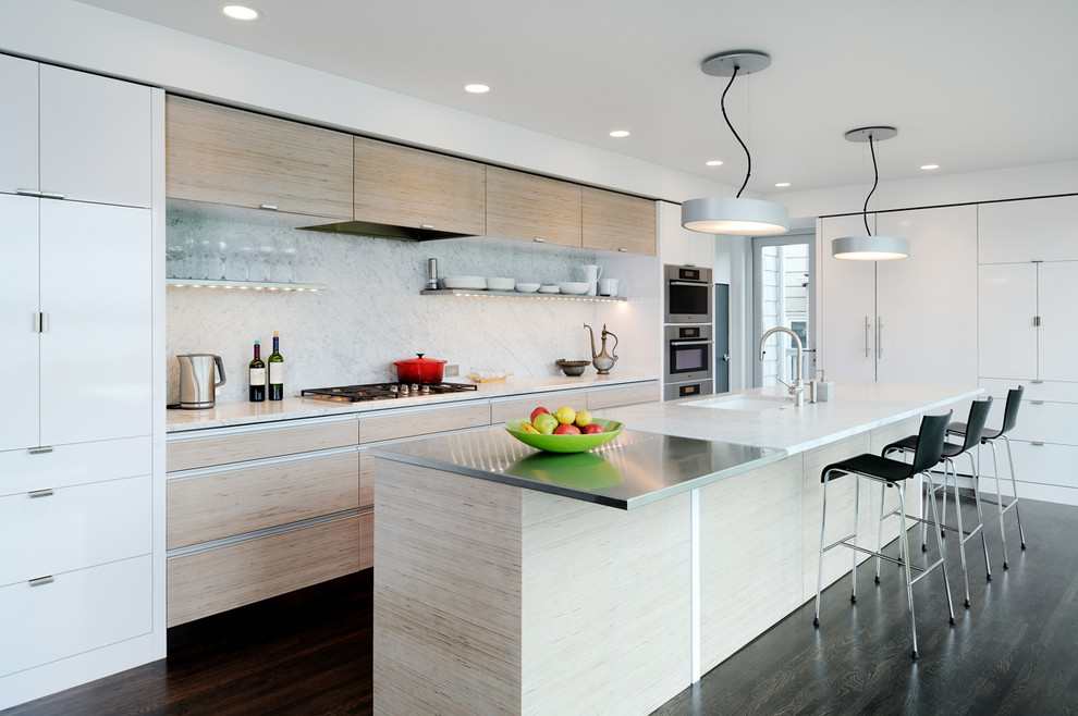 Design ideas for a contemporary galley eat-in kitchen in Seattle with an undermount sink, flat-panel cabinets, light wood cabinets, white splashback, stone slab splashback, stainless steel appliances and marble benchtops.