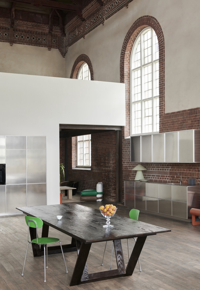 Industrial single-wall kitchen in Copenhagen with grey cabinets, stainless steel benchtops and grey benchtop.