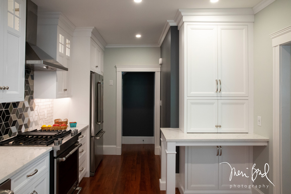 Inspiration for a mid-sized transitional l-shaped dark wood floor and brown floor open concept kitchen remodel in Minneapolis with a drop-in sink, beaded inset cabinets, white cabinets, quartzite countertops, multicolored backsplash, ceramic backsplash, stainless steel appliances, an island and white countertops