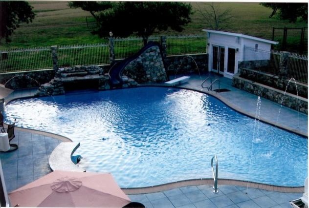 Example of a large backyard brick and custom-shaped aboveground pool design