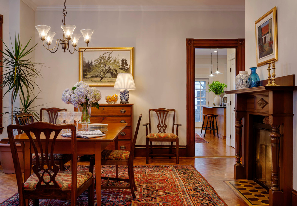 Mid-sized traditional dining room in Boston with white walls, medium hardwood floors, a standard fireplace and a wood fireplace surround.