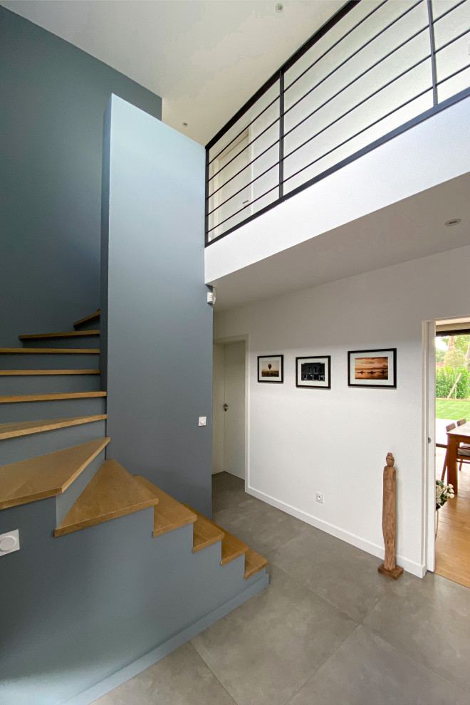 Idée de décoration pour un escalier design en U avec des marches en bois et des contremarches en béton.