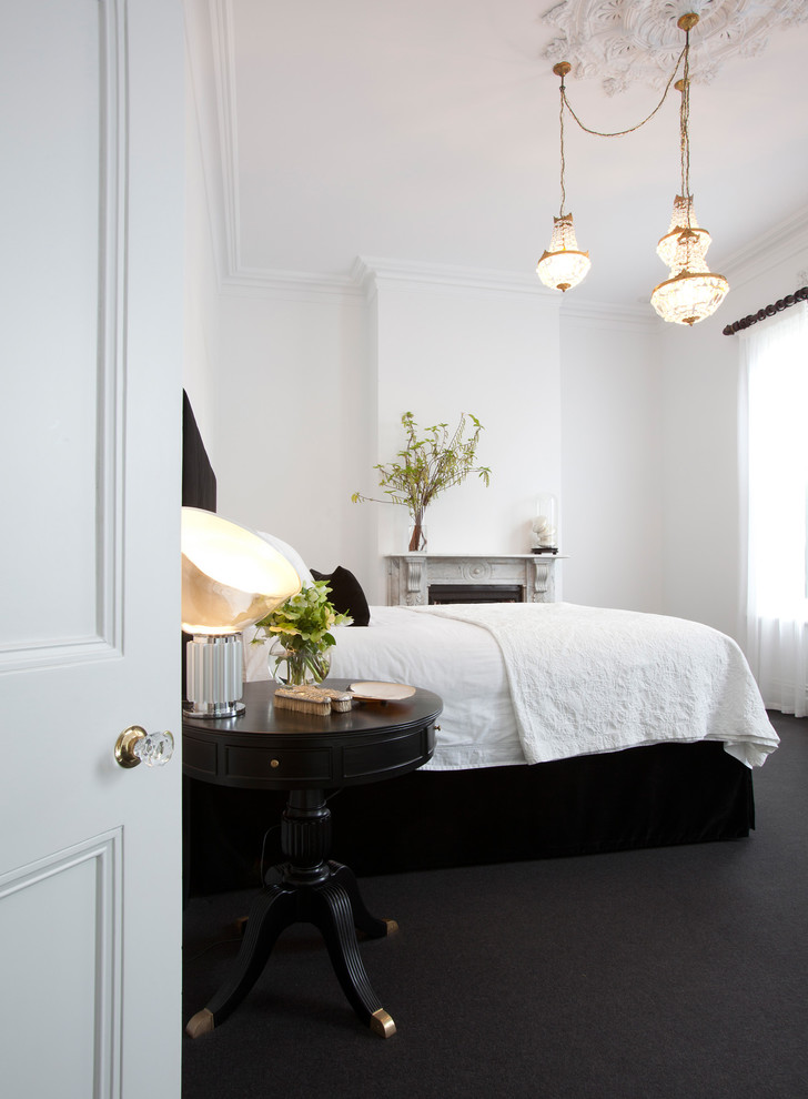 Photo of a contemporary bedroom in Melbourne with white walls, carpet, a standard fireplace and black floor.