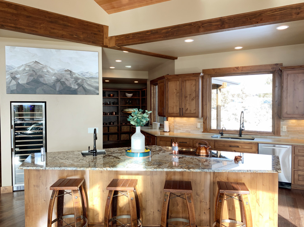 Inspiration for a large rustic u-shaped dark wood floor and brown floor open concept kitchen remodel with an undermount sink, recessed-panel cabinets, brown cabinets, granite countertops, beige backsplash, stone tile backsplash, stainless steel appliances, an island and brown countertops