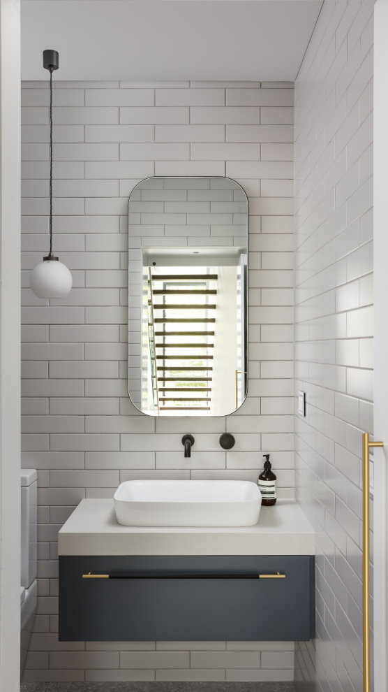 Mid-sized contemporary master bathroom in Sydney with flat-panel cabinets, blue cabinets, a drop-in tub, a corner shower, a one-piece toilet, multi-coloured tile, ceramic tile, grey walls, ceramic floors, a pedestal sink, marble benchtops, grey floor, a hinged shower door and blue benchtops.