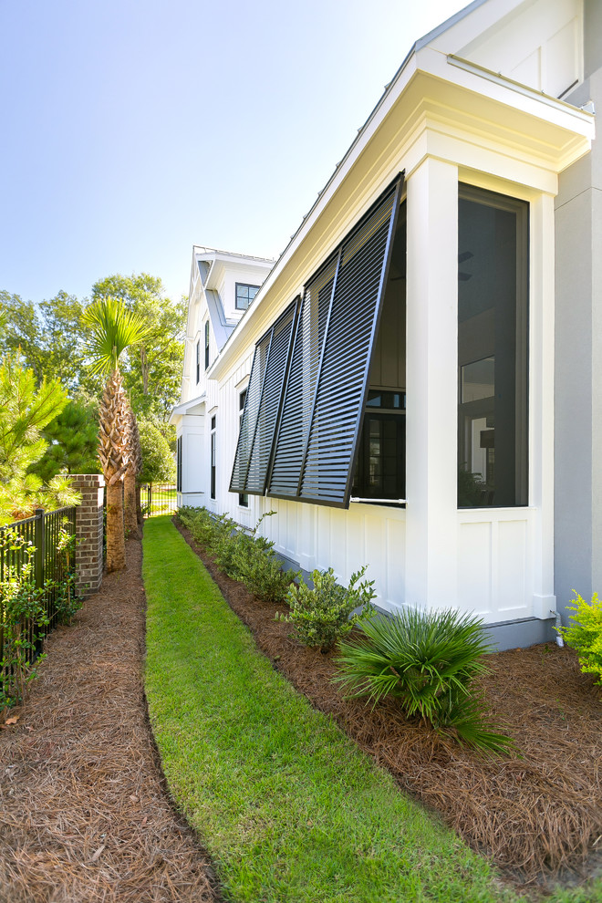 Inspiration for a small beach style two-storey white house exterior in Charleston with concrete fiberboard siding, a gable roof and a metal roof.