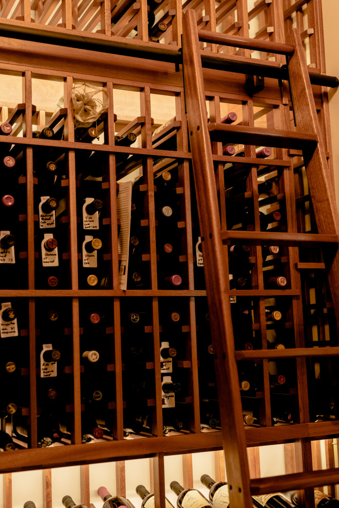 This is an example of a mid-sized transitional wine cellar in Dallas with medium hardwood floors, storage racks and brown floor.