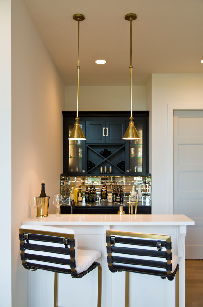 Mid-sized contemporary galley seated home bar in Kansas City with glass-front cabinets, black cabinets, granite benchtops, mirror splashback, light hardwood floors, brown floor and multi-coloured benchtop.