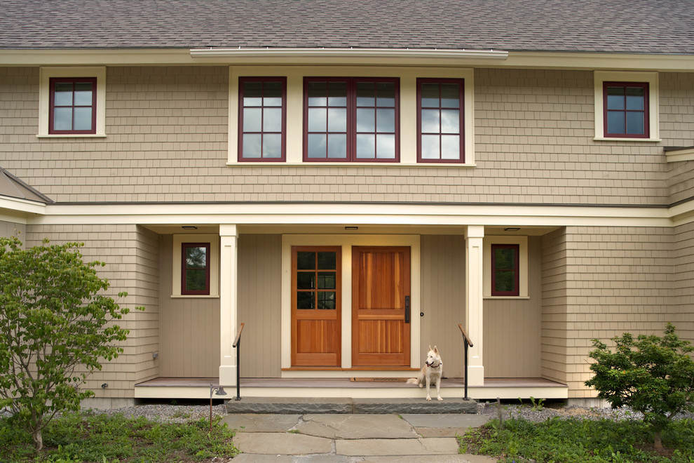 Country two-storey beige exterior in Manchester with wood siding.