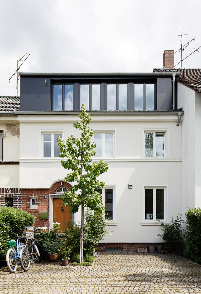 Photo of a mid-sized contemporary three-storey white exterior in Cologne with mixed siding.