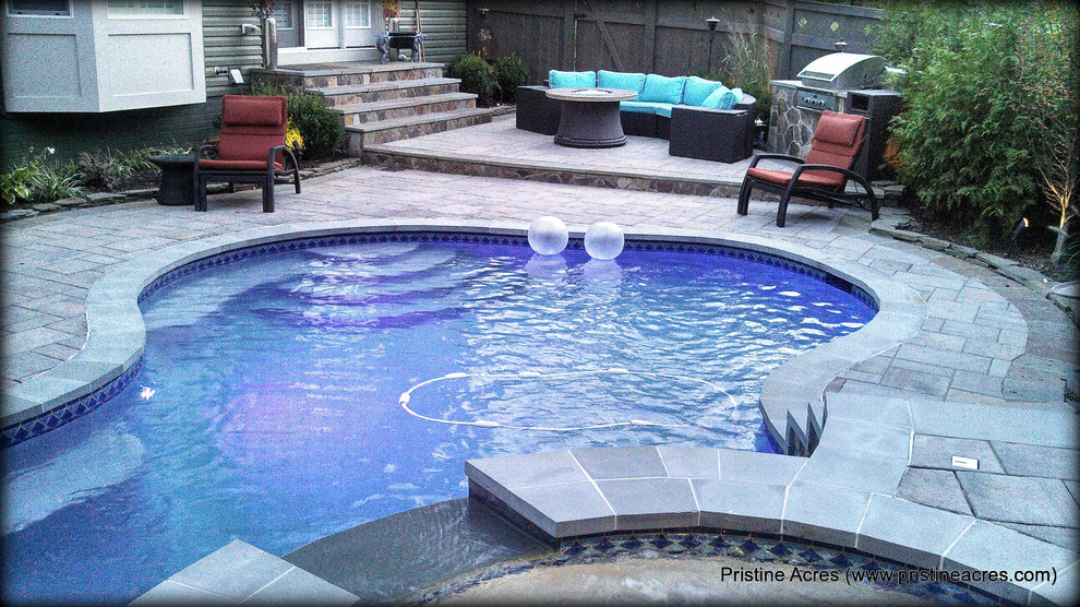 Example of a huge transitional backyard concrete paver and custom-shaped natural pool fountain design in DC Metro