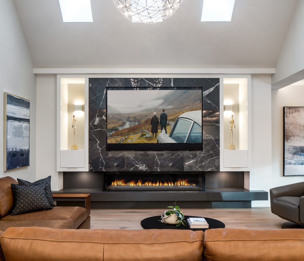 Design ideas for a large contemporary open plan games room in Vancouver with white walls, light hardwood flooring, a corner fireplace, a tiled fireplace surround, a built-in media unit, brown floors and a vaulted ceiling.