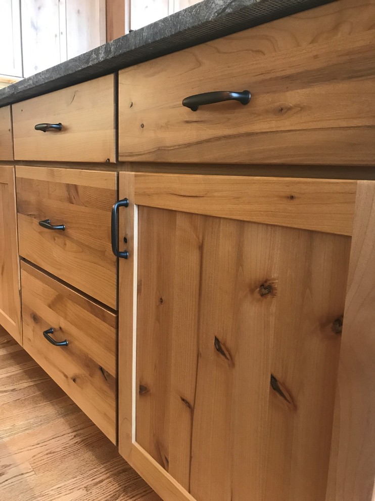 Large mountain style l-shaped medium tone wood floor and brown floor home design photo in Chicago with an undermount sink, shaker cabinets, medium tone wood cabinets, granite countertops, green backsplash, slate backsplash, stainless steel appliances, an island and black countertops