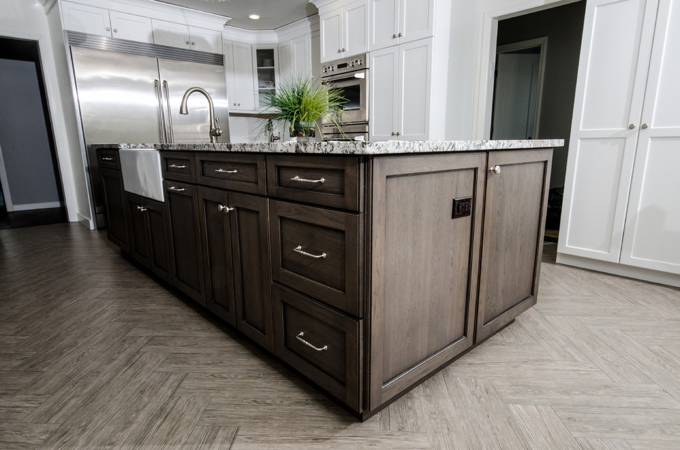 Inspiration for a large transitional u-shaped porcelain tile eat-in kitchen remodel in New York with a farmhouse sink, shaker cabinets, white cabinets, granite countertops, white backsplash, stainless steel appliances and an island