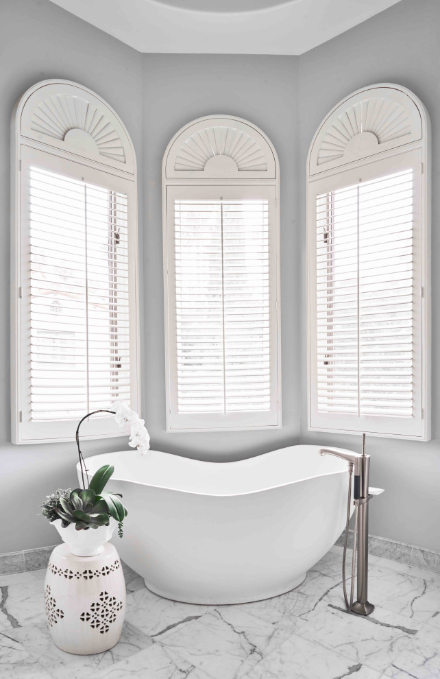 Example of a large tuscan master gray floor freestanding bathtub design with gray walls