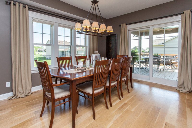 Example of a mid-sized transitional light wood floor kitchen/dining room combo design with gray walls and no fireplace