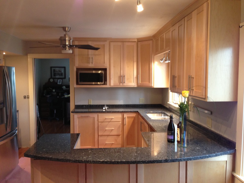 Enclosed kitchen - small transitional u-shaped medium tone wood floor enclosed kitchen idea in Chicago with a double-bowl sink, shaker cabinets, light wood cabinets, quartzite countertops, stainless steel appliances and a peninsula
