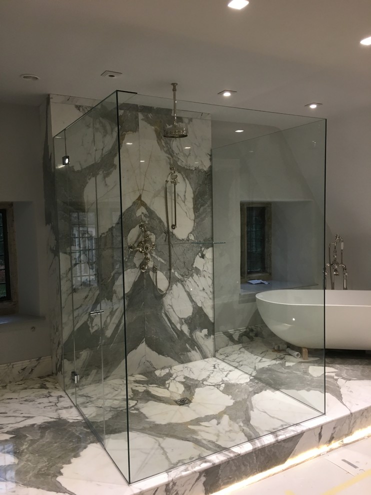 Esempio di una grande stanza da bagno con doccia minimalista con vasca freestanding, zona vasca/doccia separata, piastrelle grigie, lastra di vetro, pareti grigie e pavimento in marmo