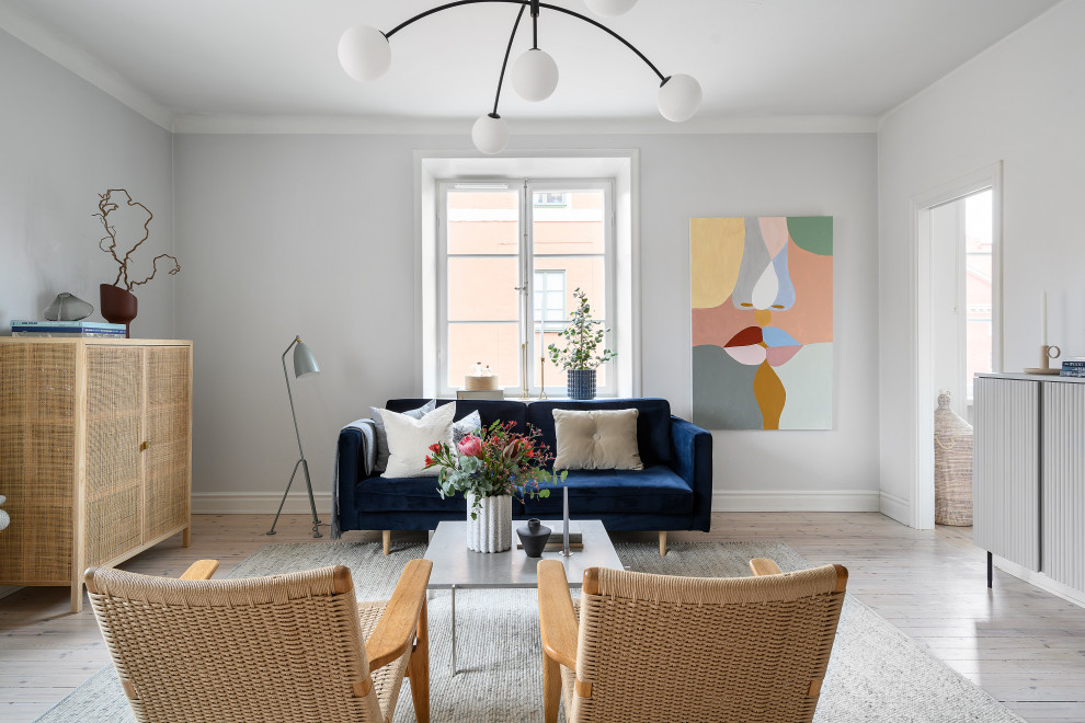 This is an example of a small scandi open plan living room in Stockholm with grey walls, light hardwood flooring, no fireplace, a wall mounted tv and white floors.