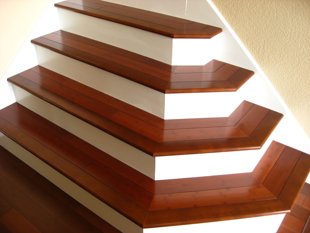 Idée de décoration pour un escalier peint courbe avec des marches en bois.