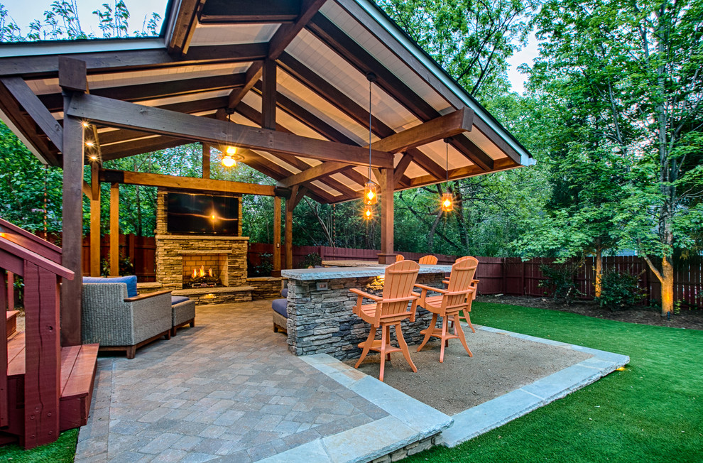 This is an example of a mid-sized arts and crafts backyard patio in Charlotte with a fire feature, concrete pavers and a gazebo/cabana.