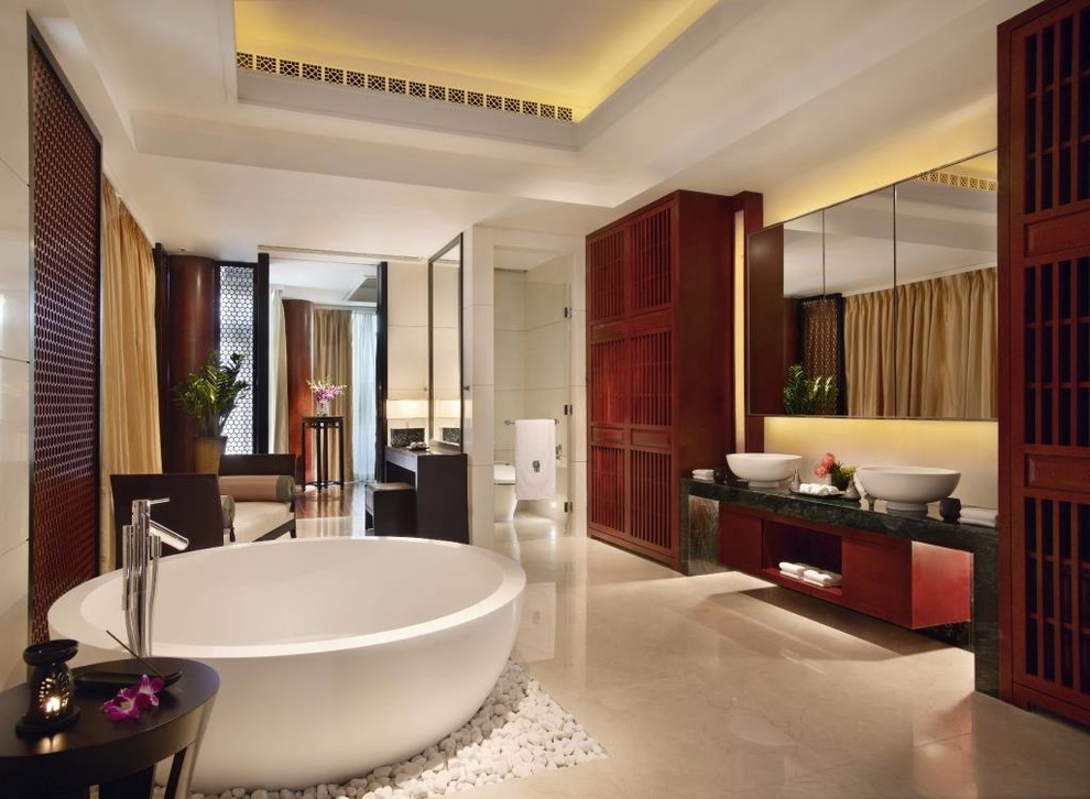 Inspiration for an expansive asian master bathroom in Melbourne with a vessel sink, furniture-like cabinets, red cabinets, granite benchtops, a freestanding tub, an open shower, a one-piece toilet, beige tile, porcelain tile, white walls and porcelain floors.