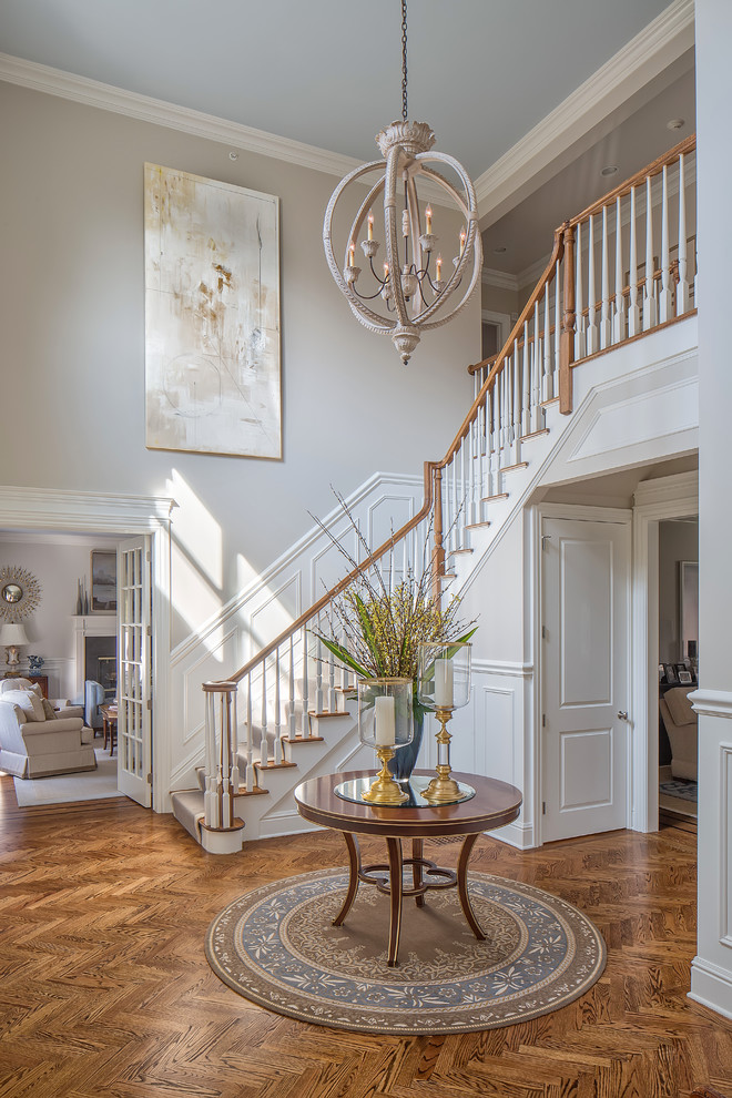 This is an example of a large traditional foyer in Other with grey walls, medium hardwood floors, brown floor and a medium wood front door.
