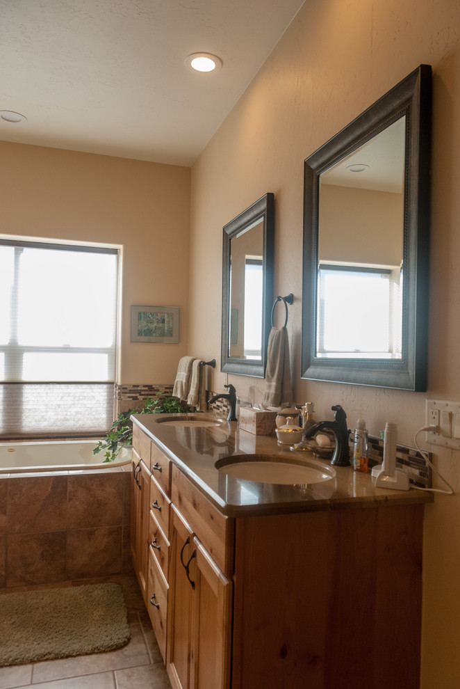 Photo of a mid-sized master bathroom in Denver with shaker cabinets, light wood cabinets, a drop-in tub, an open shower, multi-coloured tile, mosaic tile, limestone benchtops, brown benchtops, a double vanity and a built-in vanity.