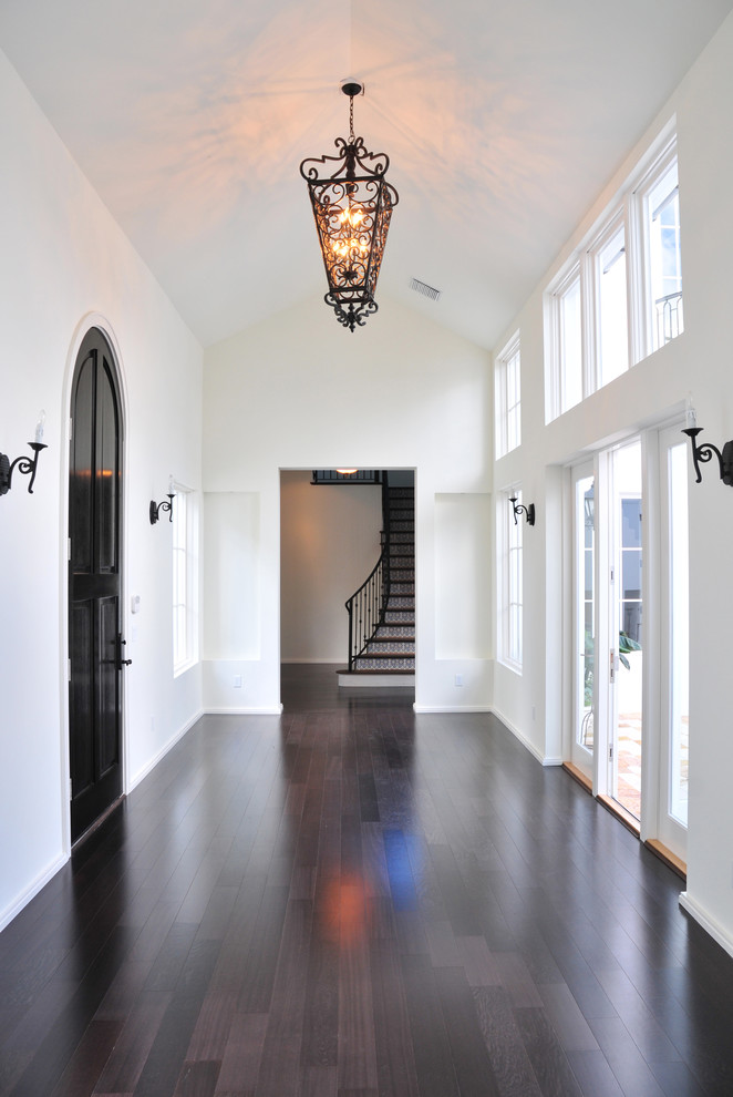 Photo of a mid-sized transitional foyer in Detroit with white walls, dark hardwood floors, a single front door, a dark wood front door and brown floor.
