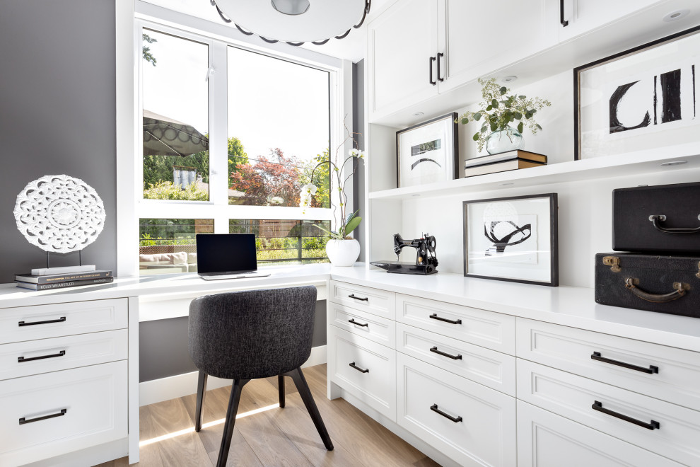 Mittelgroßes Klassisches Arbeitszimmer mit Arbeitsplatz, grauer Wandfarbe, braunem Holzboden und Einbau-Schreibtisch in Vancouver